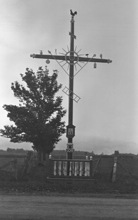 Croix de chemin rige en 1902 avec extrmits  dcor trefl, axe ornement d'une couronne en soleil et niche sur la hampe. L'Ancienne Lorette, Qubec, 1919., © MCC/CMC, Marius Barbeau, 45887