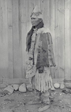 Christine TsEkEnlxEmux, a Nlaka'pamux (Thompson) woman, wearing traditional clothing; it consists of a type of dress usually worn by older women, on occasion also worn by young girls, beaded moccasins, fringed, painted leggings, and a fringed skirt, all made of buckskin., © CMC/MCC, J.A. Teit, 23211
