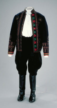 Cette veste fait partie d'un costume qui est habituellement porté lorsqu'on danse le verbunk ou le legenyes. Elle est confectionnée de laine bleu marine, brodée de fil vert et rouge, et décorée d'un motif de tulipes ainsi que de perles noires., © MCC/CMC, 89-4.3