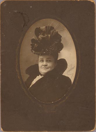 Photographie d'une femme portant un chapeau élaboré