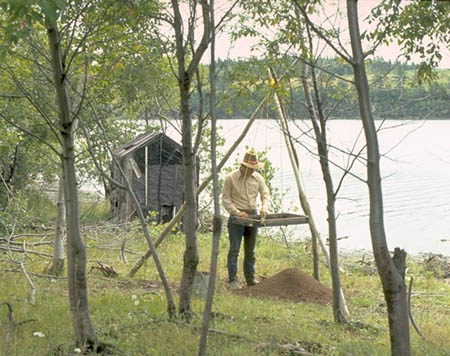 Un homme fouillant le sol sur un site archéologique.