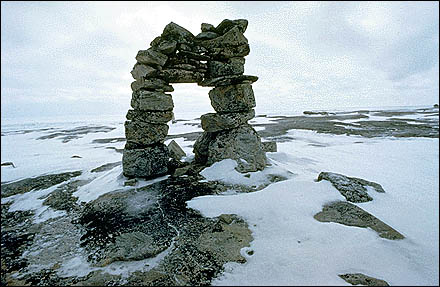 Un Inukshuk, au milieu d'un vide enneigé.