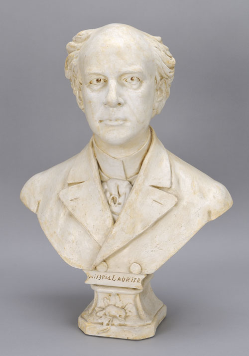 Buste en plâtre blanc de sir Wilfrid Laurier, qui aurait été sculpté par Alfred Laliberté. Le nom « Wilfrid Laurier » est gravé sur le devant du socle. Musée canadien de l’histoire, 2011.21.315