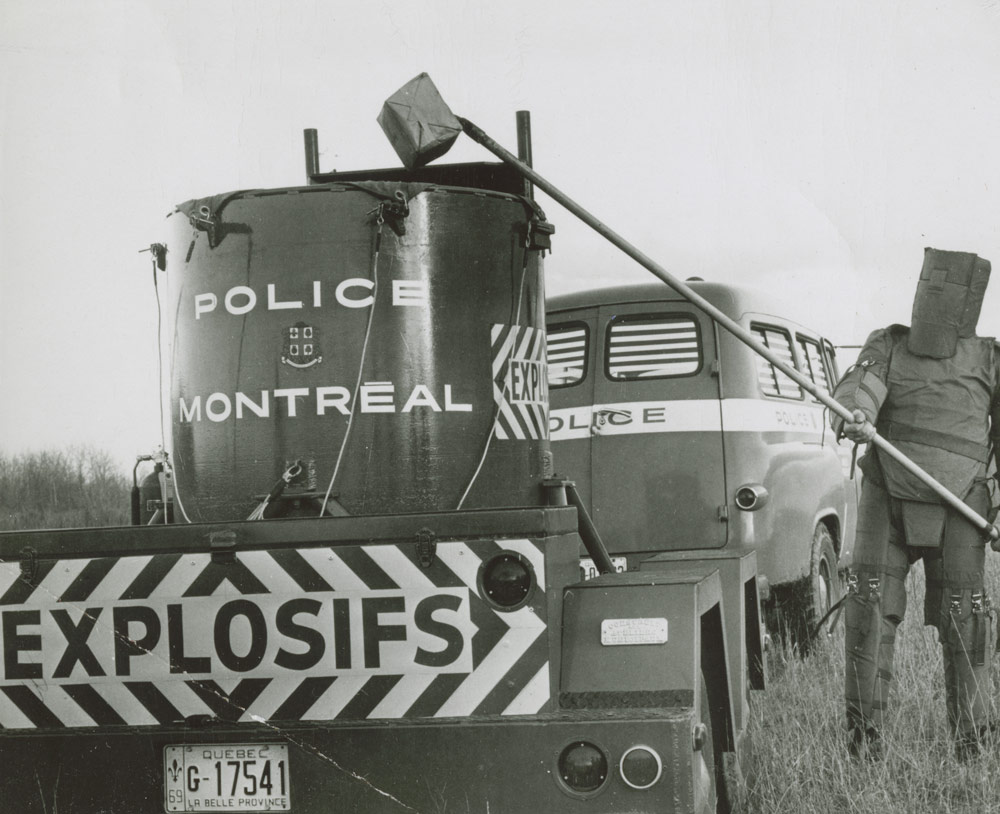 Le sergent Robert Côté, à droite de la remorque anti-bombes de la police de Montréal, en 1968. Musée canadien de l’histoire, Archives photographiques, IMG2016-0278-0001-Dm, photographe inconnu.