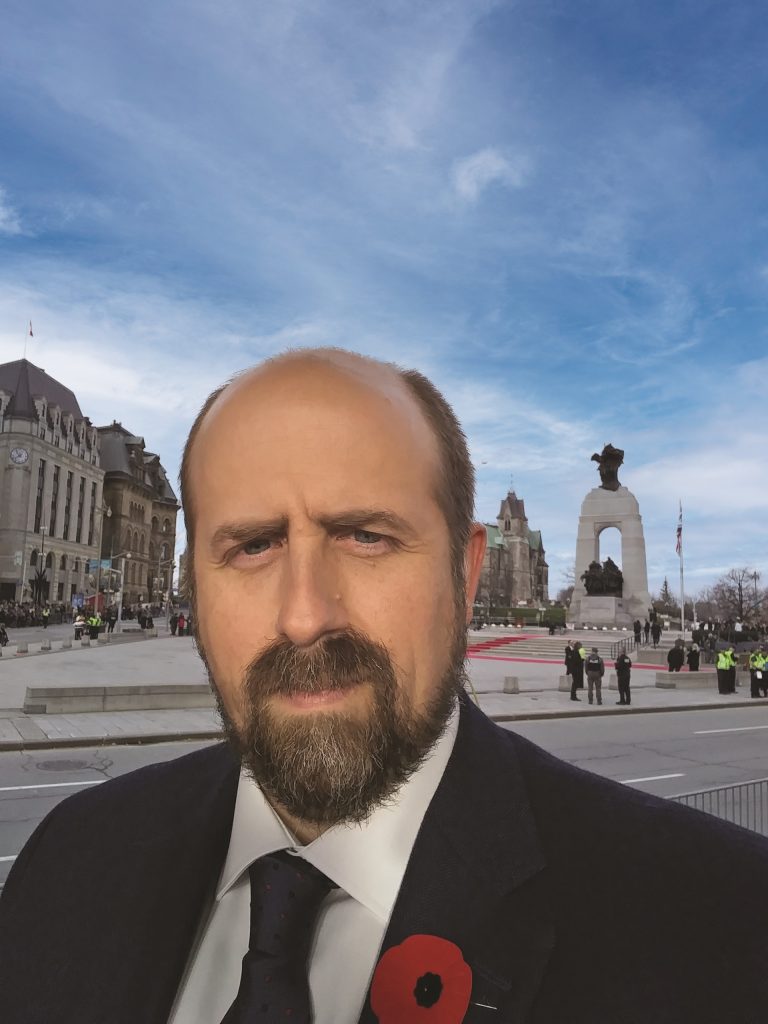 Image d'Andrew Burtch devant le Monument commémoratif de guerre, Ottawa