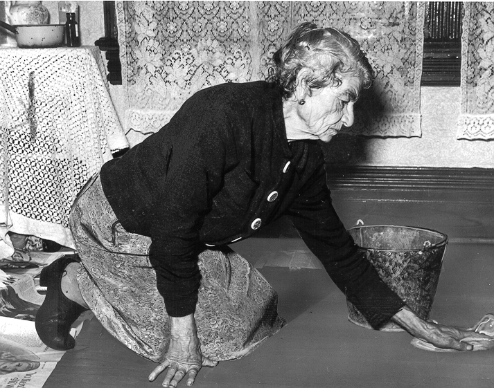 Pensionnée en train de nettoyer un plancher pour augmenter son revenu de pension, v. 1947 - ANC, détail de PA93924