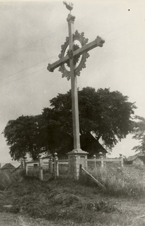 Croix de chemin avec extrmits  dcor trefl avec coq  la cime et couronne. Boucheville, Qubec, [191-]., © MCC/CMC, Edouard Zotique Massicotte, B556-10.16