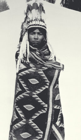 Jeune homme nlaka'pamux (thompson) emmitoufl dans une couverture en poils de chvre et portant une coiffure orne de plumes d'aigle, Colombie-Britannique, © MCC/CMC, J.A. Teit, 30991