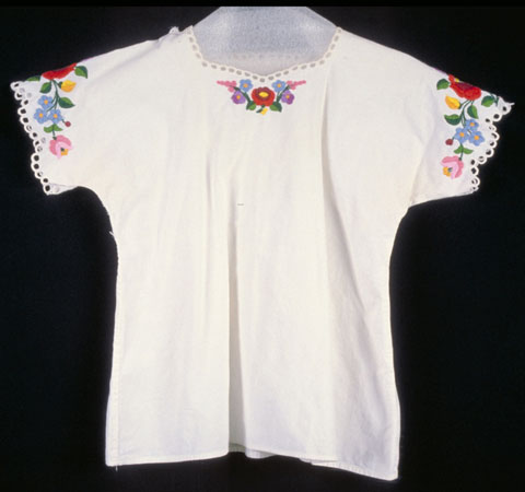 Blouse de femme à manches courtes en coton blanc, au motif floral brodé multicolore autour des manches et d'une partie du col. Élément d'un costume traditionnel., © MCC/CMC, 76-514.1