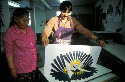 Kenojuak Ashevak et Kavavaow Mannomee dans le processus de créer l'estampe The Sun's Return, créée par la technique de la gravure sur pierre et le pochoir