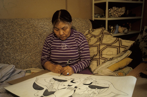 Kenojuak Ashevak utilisant un stylo-feutre à l'encre noire pour dessiner ce qui allait devenir l'estampe Guardians of the Owl