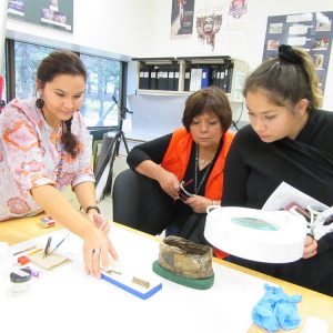Trois femmes examinent un artefact