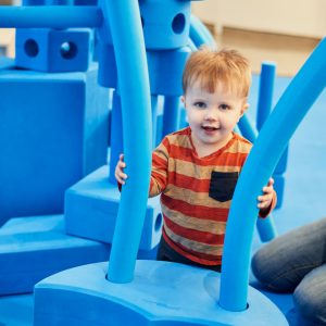 Enfant avec des morceaux de mousses bleus