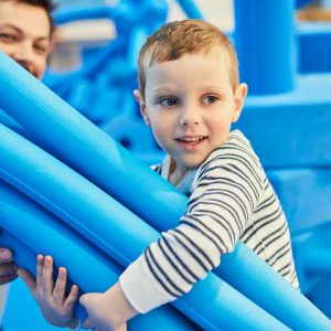 Enfant avec des morceaux de mousses bleus