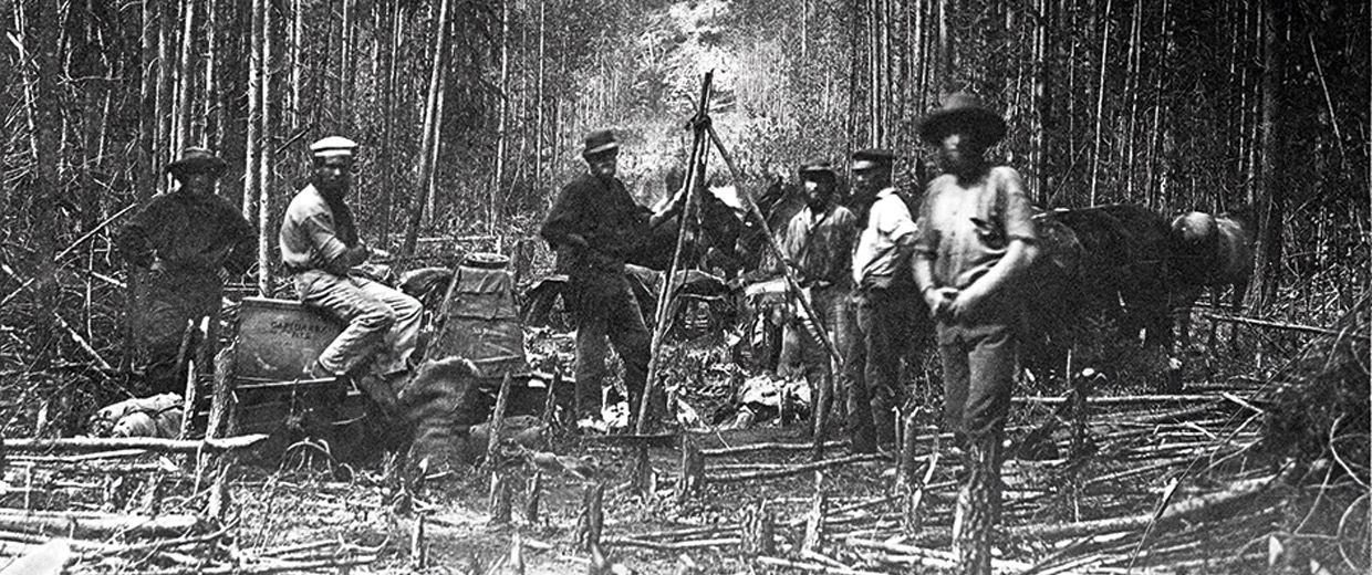 A group of men standing in a wooded area