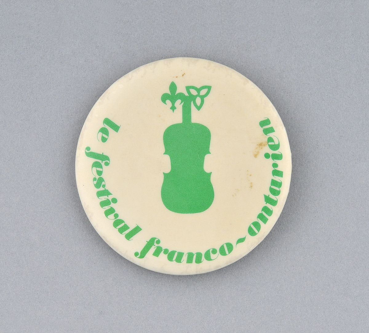 Un bouton vert avec un violon dessus, exposé au Musée canadien de l'histoire à Ottawa.