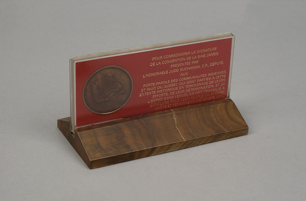 Une plaque en bois sur laquelle est gravée une médaille, exposée au Musée canadien de l'histoire à Ottawa.