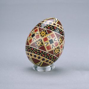 Un œuf de Pâques ukrainien décoré d’un délicat motif d’étoiles et de diamants noir, rouge, brun et blanc.