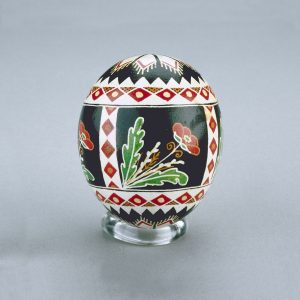 Un œuf de Pâques ukrainien décoré de formes de diamants et de triangles rouges, blanches, noires et jaunes, ainsi que des motifs de coquelicot.