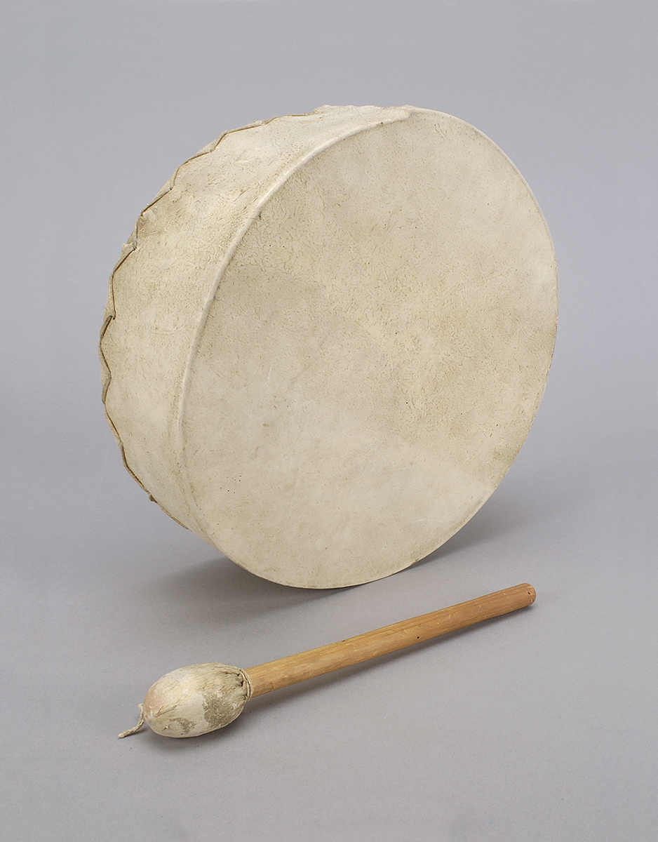 Un tambour avec un bâton en bois à côté au Musée canadien de l'histoire.