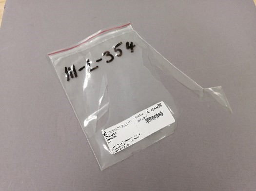 Un sac en plastique déchiré de type Ziploc avec des étiquettes imprimées et manuscrites.